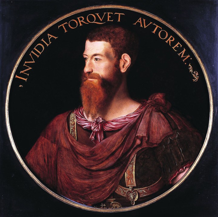 A portrait of the head and chest of a white man wearing classical/stereotypical roman attire. He is wearing a red tunic with gold decorations and a red toga. He has red short hair and a long beard and moustache. Above him is a Latin inscription: Invidia Torqvet Avtorem. 