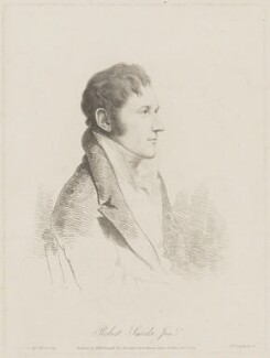 A half-length pencil sketch portrait of Robert Smirke. Sitting side on, he is wearing a dark suit jacket with a low opening on the chest and wide lapels, and a white shirt with a thick white scarf tied around his neck. He is clean shaven with sideburns below his ears and short dark hair. 