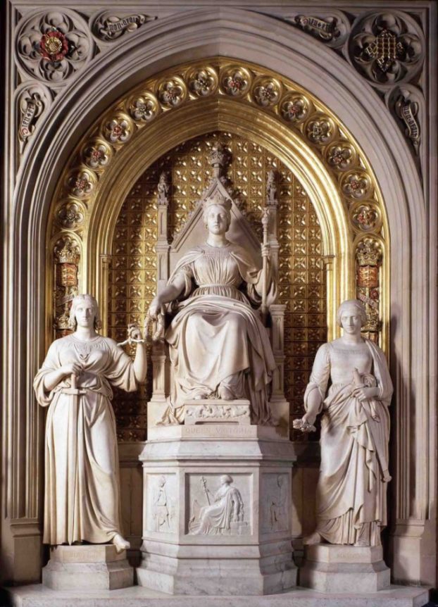 A statue of a queen on a throne with two women to either side