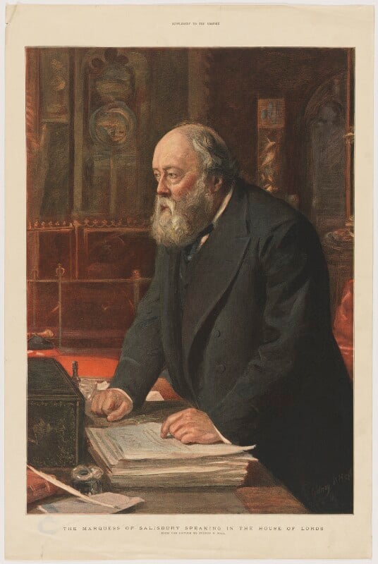 A half-length portrait of Robert Gascoyne-Cecil, 3rd Marquess of Salisbury speaking in the House of Lords. Standing at the despatch box , he has his right hand on the table, and his left on top of a large stack of papers, Looking to the left, he is wearing a black Victorian suit, with a thick black suit coat. waistcoat, black tie and white collared shirt. He is bald with medium length grey hair on the back and sides of his head, as well as a full bushy grey beard.