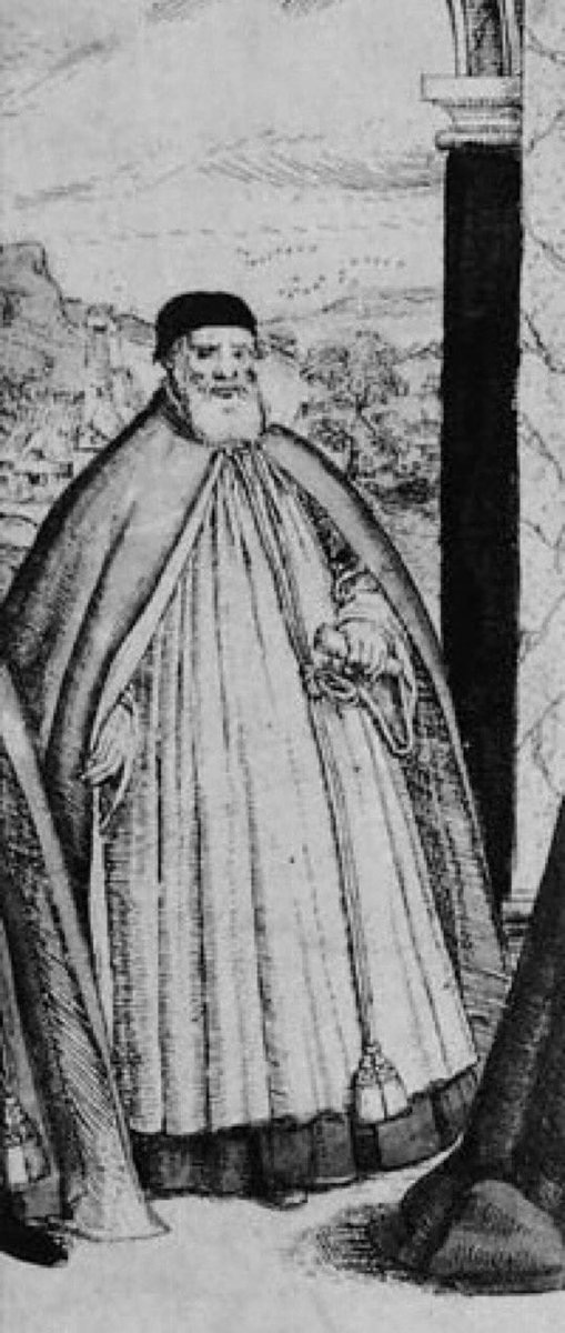 Old man with white beard, dressed in a long cloak and ecclesiastical vestments, and holding a rolled-up scroll. In the background is a countryside view.