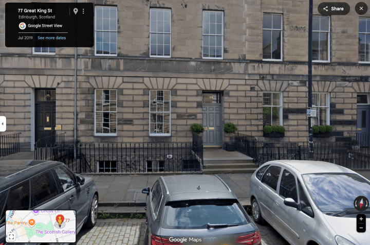 A row of terraced houses with cars outside
